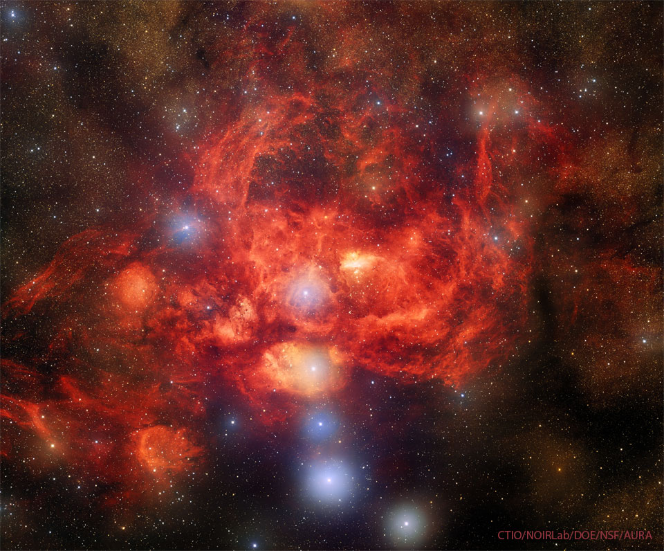 Prezentowane zdjęcie pola gwiazd z kilkoma, jasnymi i niebieskimi gwiazdami, otoczonego przez czerwono świecącą mgławicę, 
może przypominać homara. Więcej informacji w opisie poniżej.