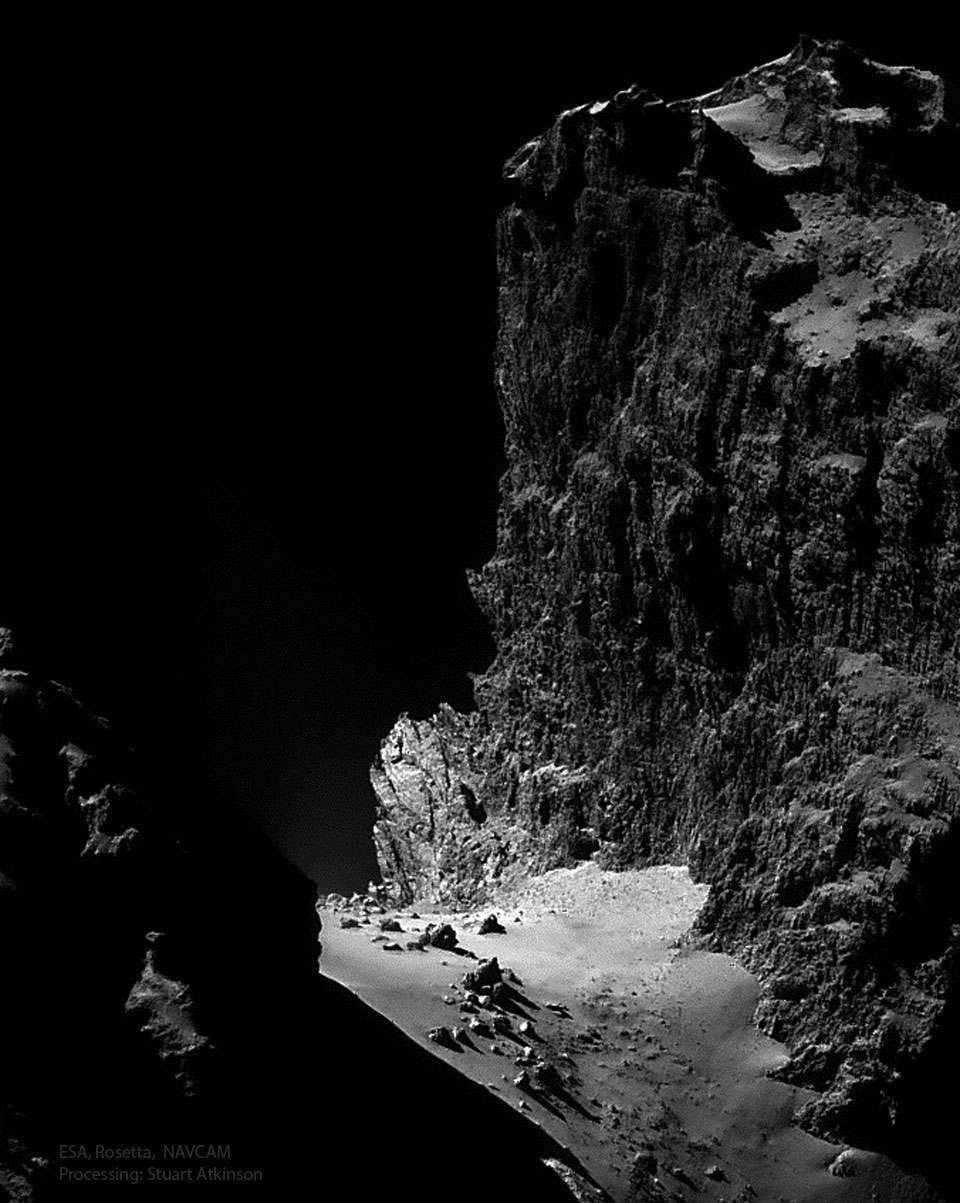 A black and white image shows, from the side, the wall
of a high jagged cliff. At the bottom of the cliff is 
a smooth landing dotted with rocks. 
Więcej szczegółowych informacji w opisie poniżej.