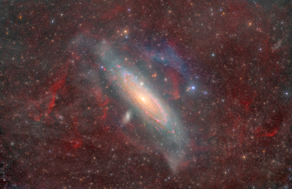 Obraz przesłonięty jest przez włókniste obłoki pyłu i&nbsp;gazu, znajdujące się w&nbsp;Drodze Mlecznej. 
Widać liczne gwiazdy Drogi Mlecznej. Andromeda jest zwartą galaktyką spiralną, pełną gazu, pyłu oraz gwiazd, 
znajdującą się w&bnsp;środku zdjęcia. Blisko niej widać klika mniejszych galaktyk, które wyglądają jak jasne grupki gwiazd.
